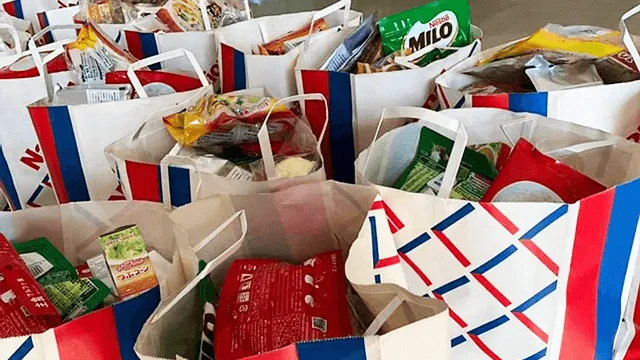 写真:写真に収まりきらない数の紙袋にそれぞれ食べ物が分けられている
