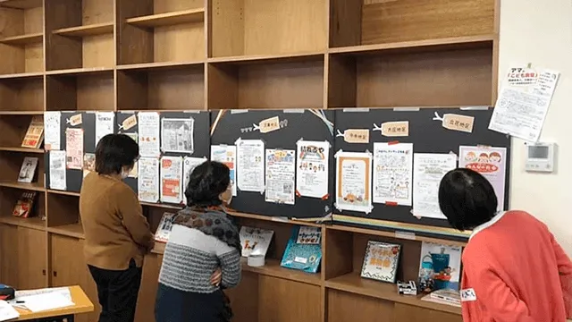 写真:掲示板に貼られたチラシを読む方達